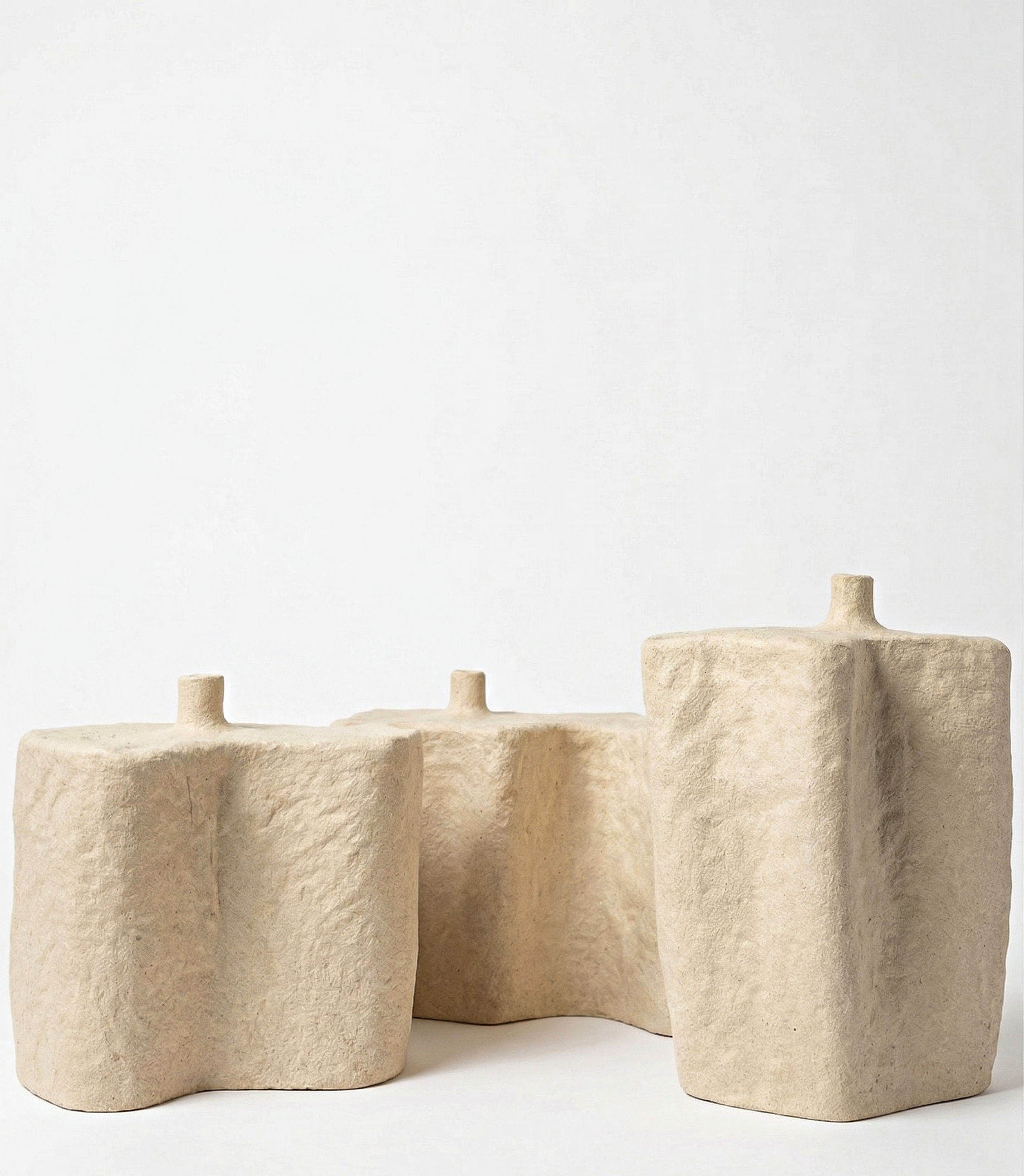 set of three handmade white ceramic sculptural objects with organic forms and textured matte surfaces
